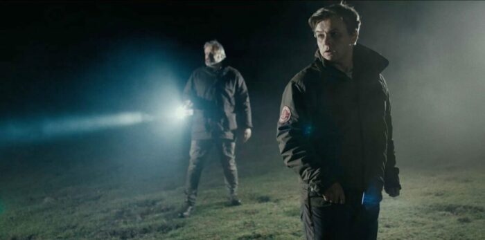 People outdoors with flashlights