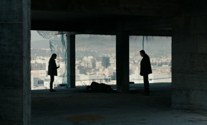 Two people standing next two a dead body