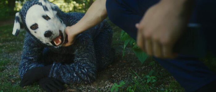 A person petting a guy in a dog suit