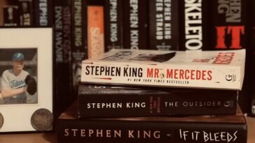 A Stephen King bookshelf with a framed photograph of Stephen King