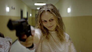 A woman holding a gun and looking deranged