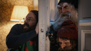 A man trying to keep elves from getting through a door