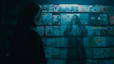 A nun looking at an image of Valak in magazines