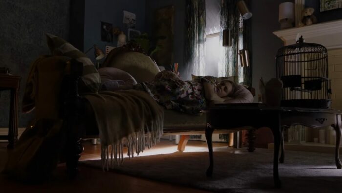 Angela lays on the couch, depressed about a missed job opportunity