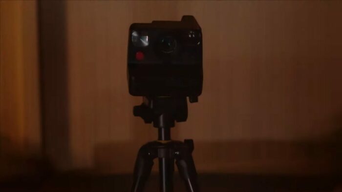 A polaroid camera stands center frame