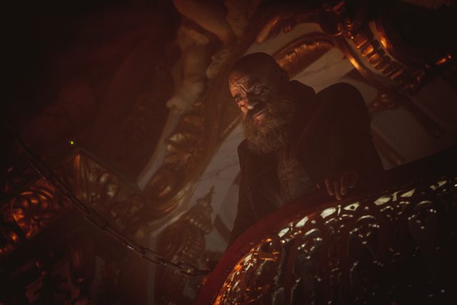 Padre Vergara looks over a balcony in hell, trying to help Elena escape