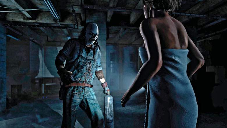 A tense scene from a video game depicting a woman in a towel facing away from the viewer, looking over her shoulder towards a menacing figure. The figure is a man wearing a blue mechanic's coverall, splattered with blood, and wielding a flamethrower. They are in a dimly lit basement with exposed beams and concrete surroundings, which adds to the ominous atmosphere of the encounter.