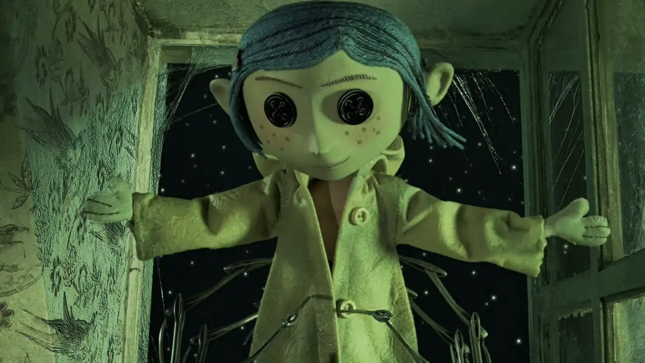 A close-up of the Other Coraline, standing with arms outstretched, wearing a yellow raincoat. She has button eyes and is surrounded by green walls with cobwebs and a starry night sky visible behind her.