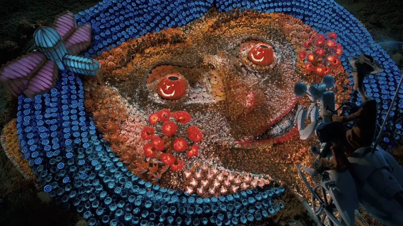 A bird's-eye view of an elaborate flower garden arranged to resemble Coraline's face, with blue flowers forming her hair, and red and pink flowers detailing her facial features, while the Other Father is seen tending to the garden.