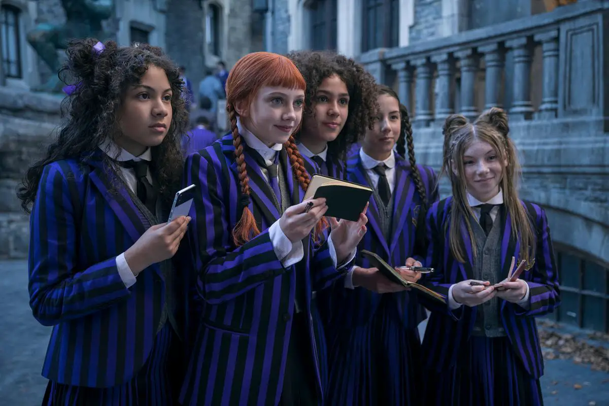 Agnes and other fans of Wednesday in a crowd holding notebooks for autographs.
